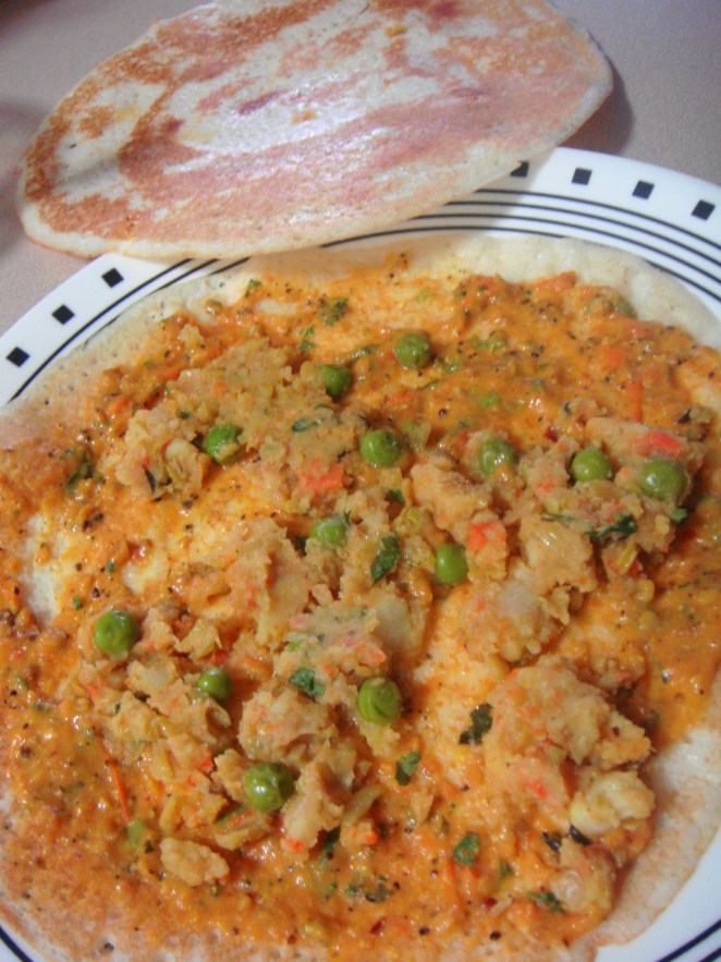 Dosa lined with chutney and vegetable filling.