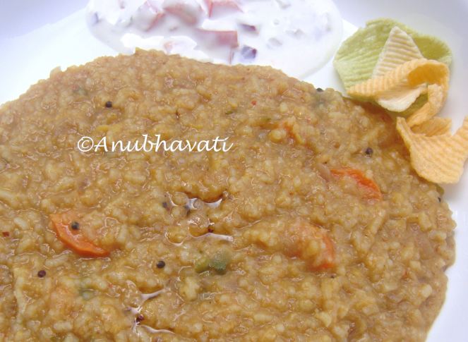 Delicious Steaming hot Bisibela Bath with ghee , raita and chips.