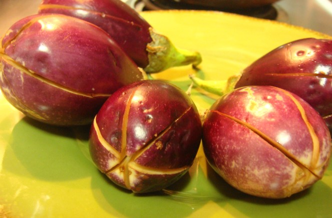 Brinjals slit and filled with drops of oil and salt.